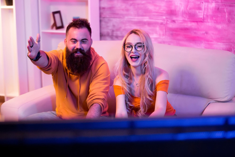 A man and woman sit on a couch.