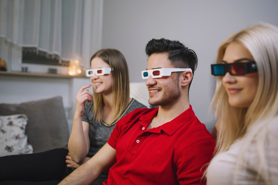 A group of three people wearing 3D glasses.