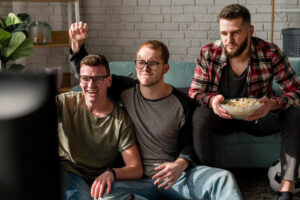 Three friends enjoying a movie night on a couch.