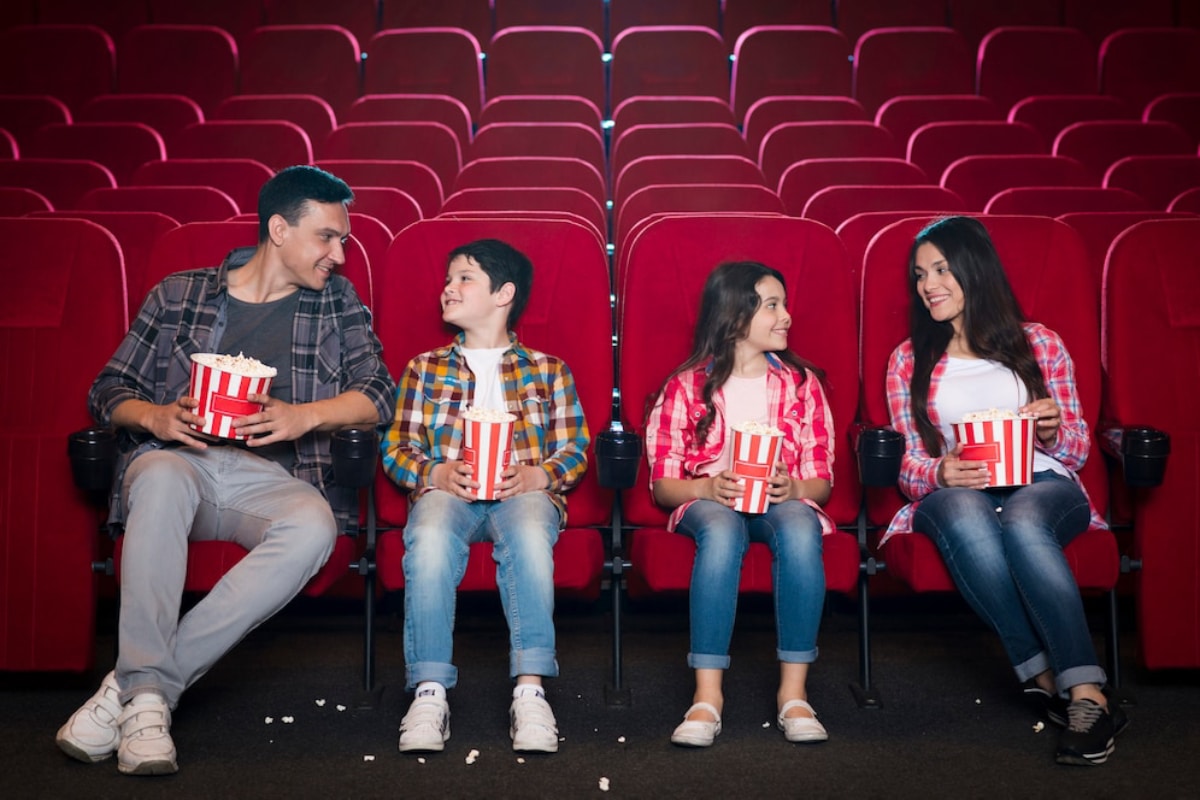 A group of four people sits in a movie theater.