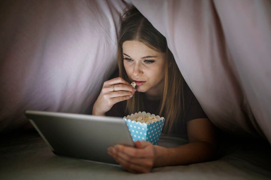 A person relaxes under a blanket.