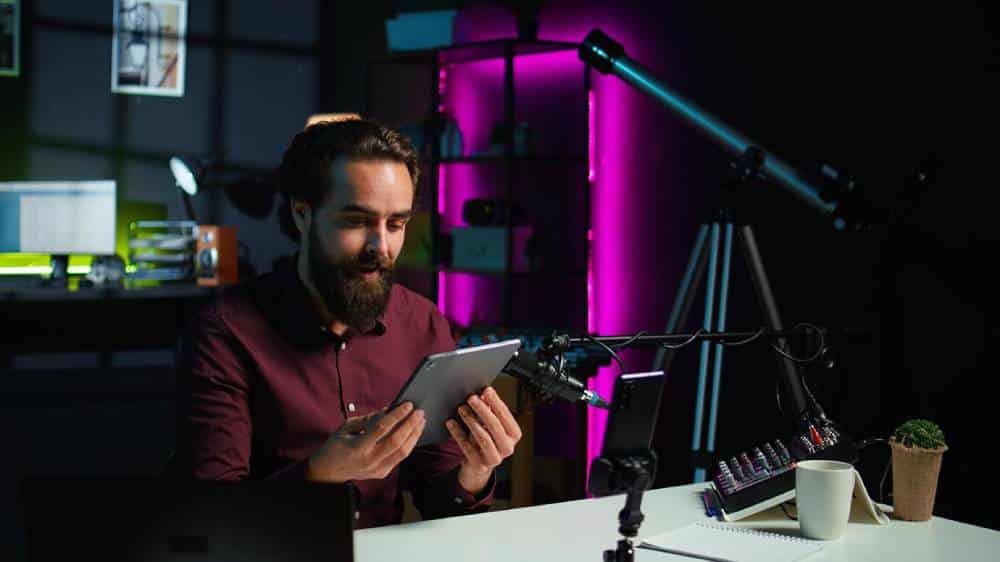 Man with beard using tablet in a modern office with moody, purple lighting