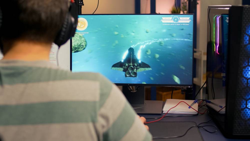 A person with headphones watching high quality video on TV.